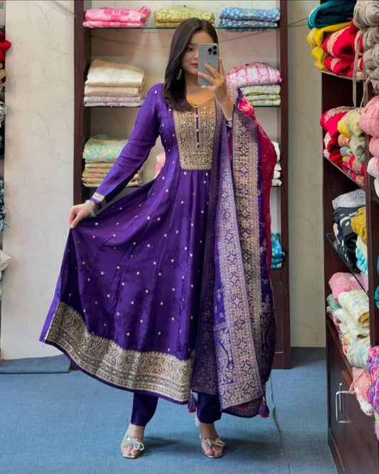 Person wearing a purple traditional outfit with gold embroidery in a store setting.