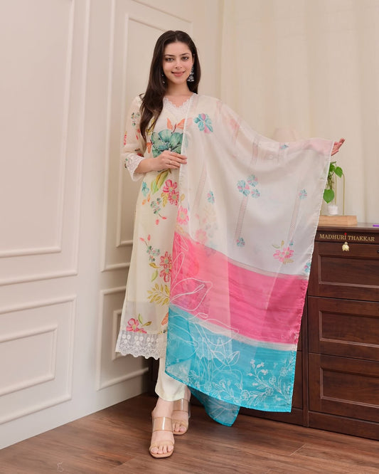 Woman holding a floral dupatta in a room with wooden furniture.